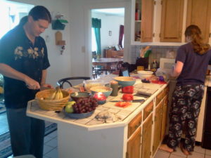 Two Men with long ponytails in the kitchen prepping food